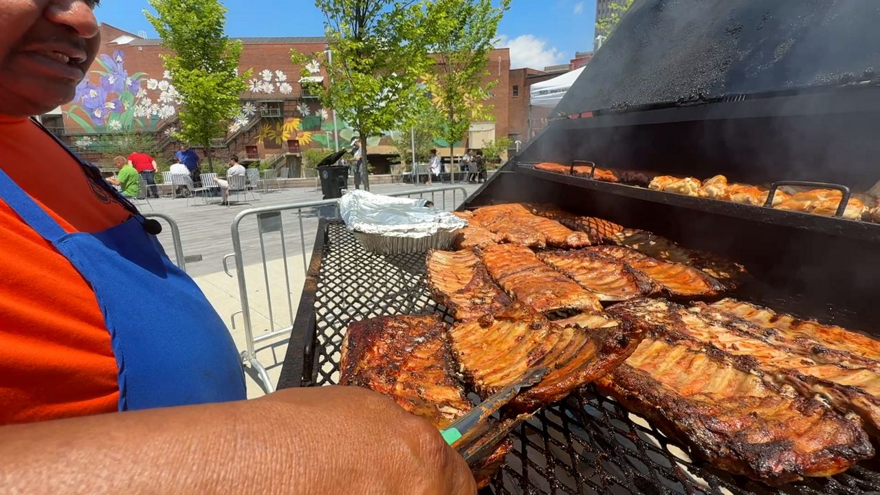 Andre Frazier is the owner of the Grill Masters Food Truck. He flips ribs on his grill at the Heart of Akron festival.