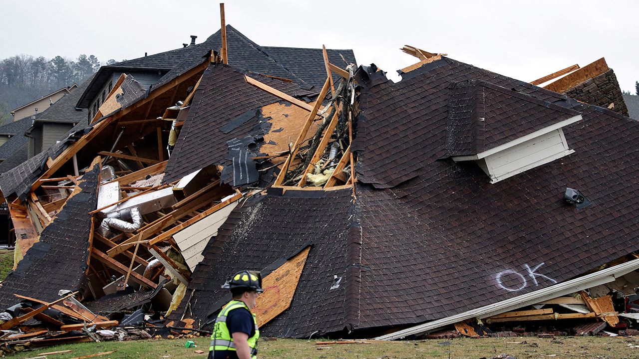 A firefighter surveys damage to a house after a tornado touches down south of Birmingham, Ala. on March 25, 2021. (AP Photo/Butch Dill)