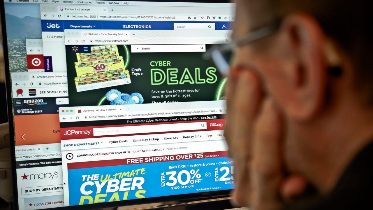 A journalist looks at a computer screen with webpages arranged to show Cyber Monday deals by various online retailers Monday Nov. 26, 2018, in New York. The physical rush of Black Friday and the armchair browsing of Cyber Monday are increasingly blending into one big holiday shopping event as more customers buy items online and pick them up at brick-and-mortar stores. (AP Photo/Bebeto Matthews)