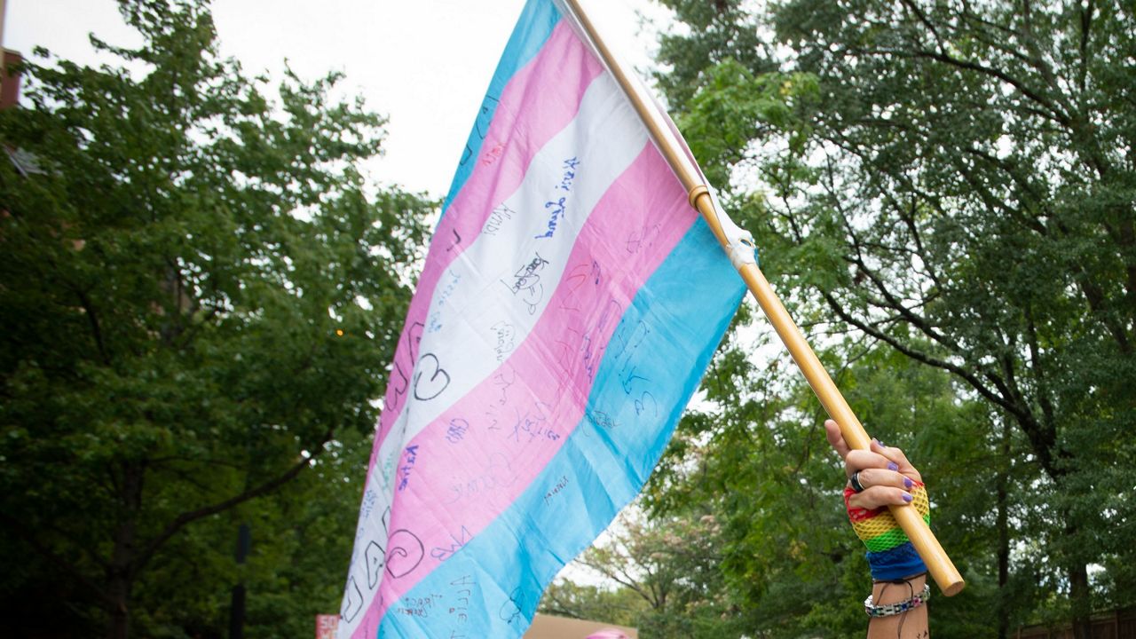 Charlotte Story, 49, a transgender woman from Macon, Ga., waves a transgender flag during a transgender rights march through the city's Midtown district in Atlanta on Saturday, Oct. 12, 2019. The march was part of the annual Gay Pride Festival. (AP Photo/Robin Rayne)