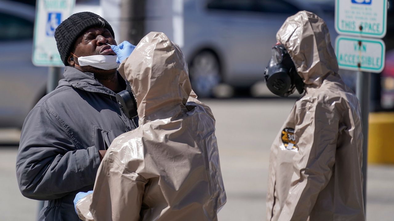 Wisconsin National Guard members administer COVID-19 tests in a parking lot Monday May 11, 2020, in Milwaukee. This was one of two sites in the city to open Monday and offer free testing. (AP Photo/Morry Gash)