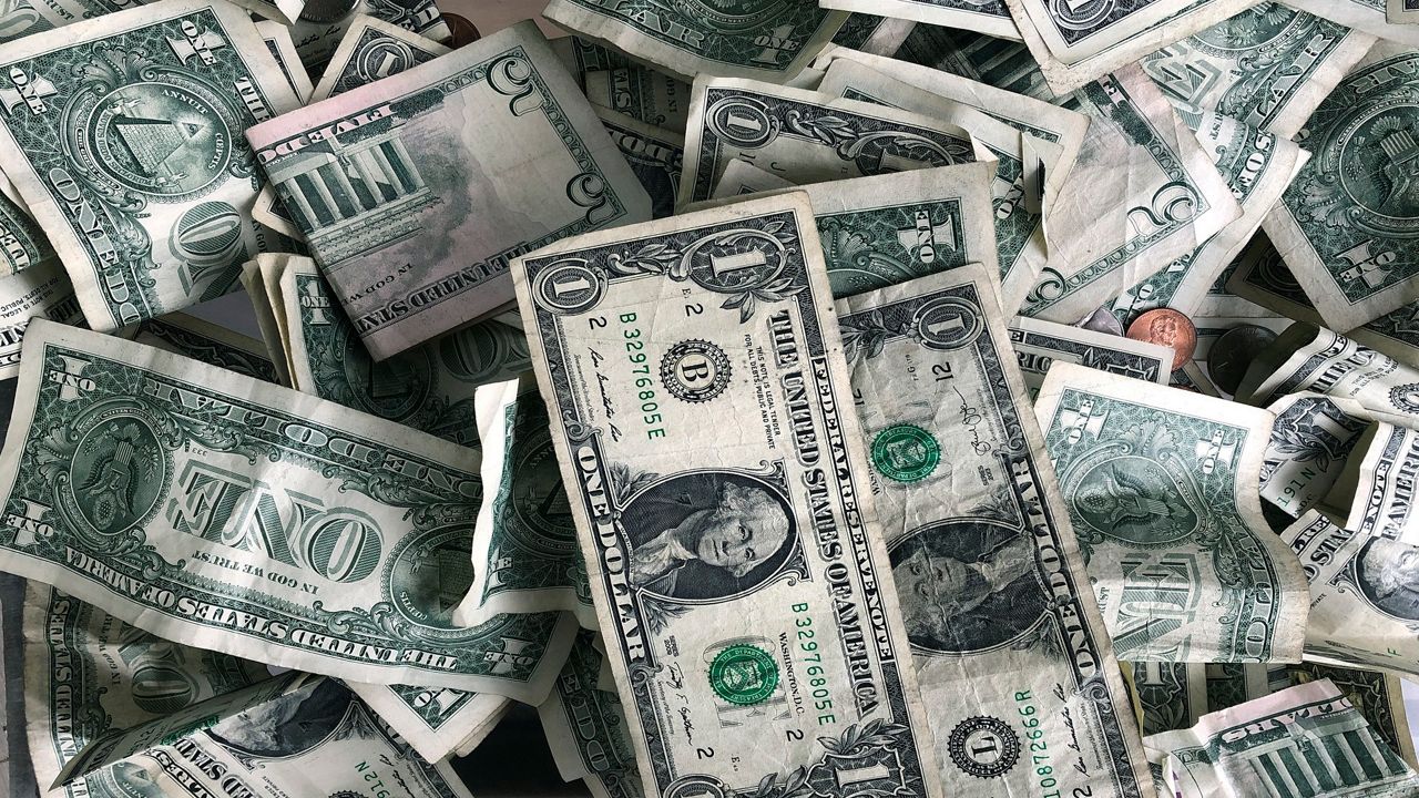 Dollar bills are deposited in a tip box. (AP Photo/Mark Lennihan)