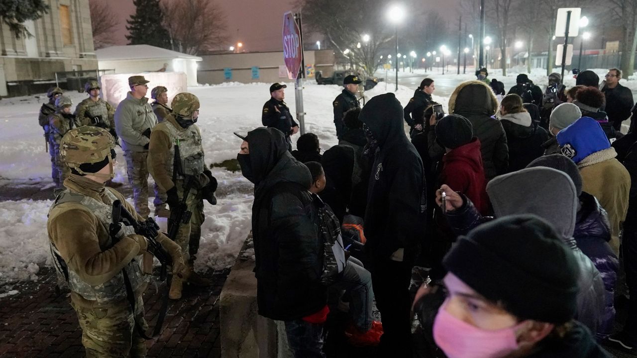 A group of protesters confront several National Guard members outside a museum, late Tuesday, Jan. 5, 2021, in Kenosha, Wis. (AP Photo/Morry Gash)