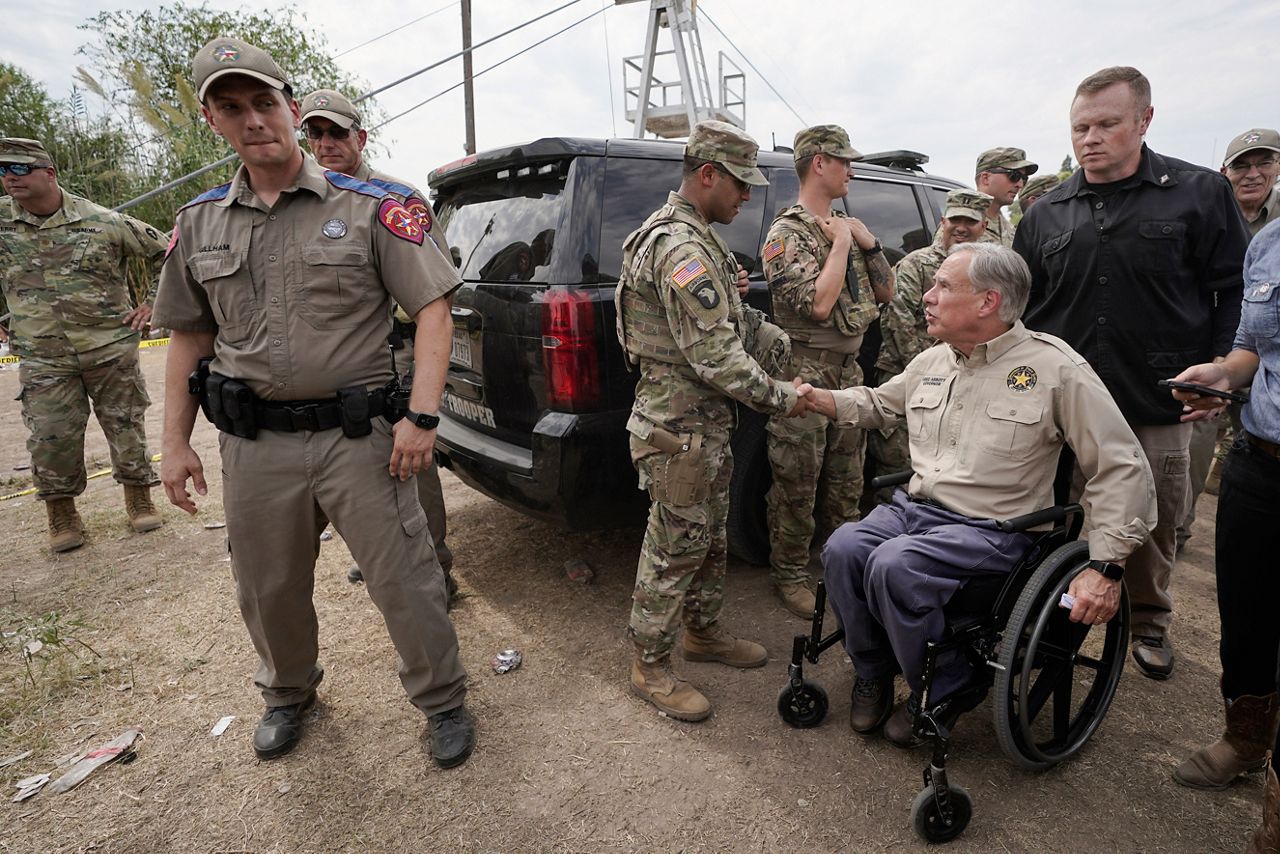Texas Gov. Greg Abbott, right, shakes a National Guard member's hand after speaking during a news conference along the Rio Grande, Tuesday, Sept. 21, 2021, in Del Rio, Texas.