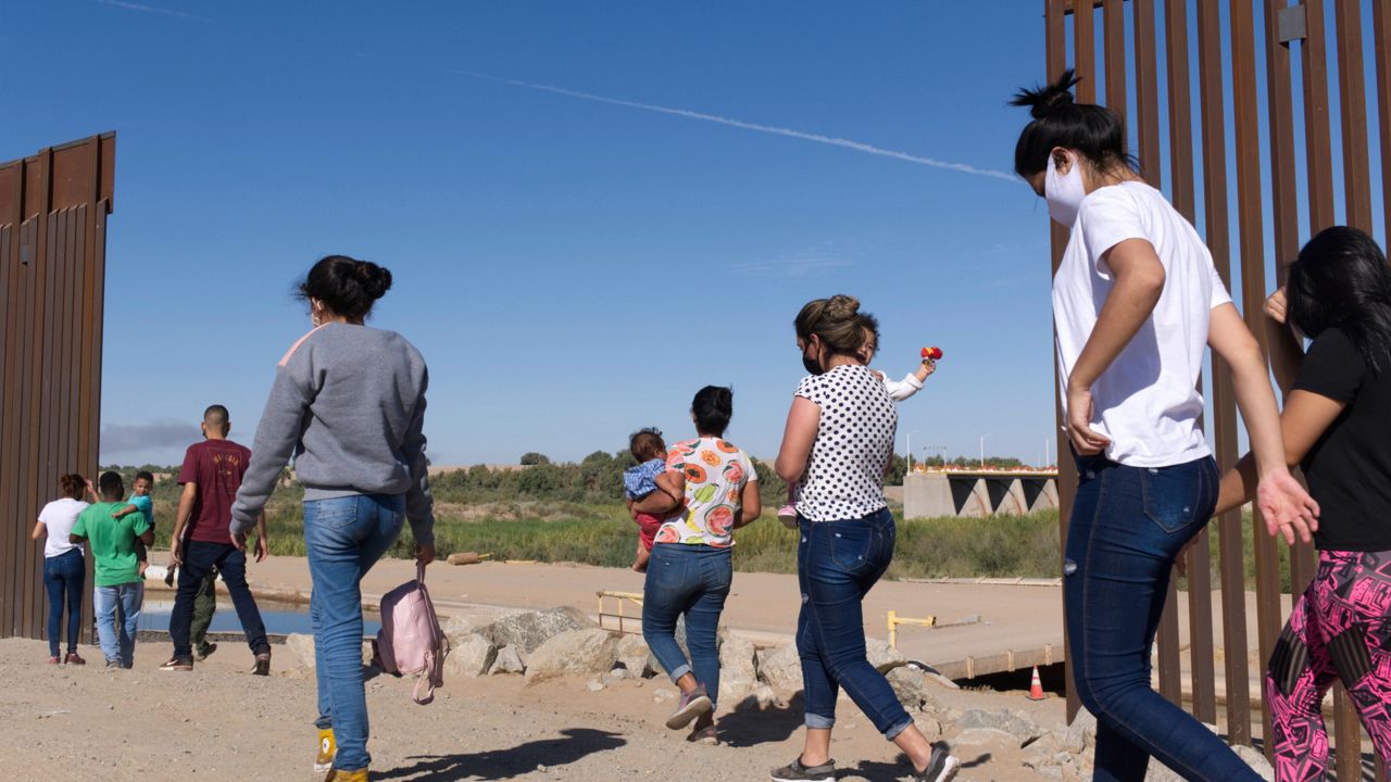 FILE - A group of Brazilian migrants make their way around a gap in the U.S.-Mexico border in Yuma, Ariz., seeking asylum in the U.S. after crossing over from Mexico, June 8, 2021. (AP Photo/Eugene Garcia, File)