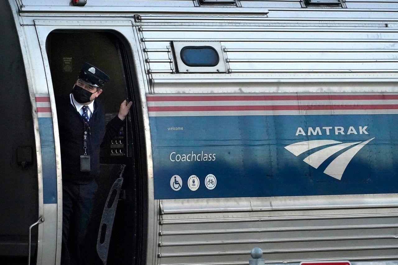 FILE - A conductor makes sure all is clear as the Amtrak Downeaster passenger train pulls out of the station, Dec. 14, 2021, in Freeport, Maine. Riders on the Amtrak train that runs from Maine to Boston will soon have to hold off on buying alcoholic beverages during the 35-mile stretch of the trip that goes through New Hampshire. (AP Photo/Robert F. Bukaty, File)