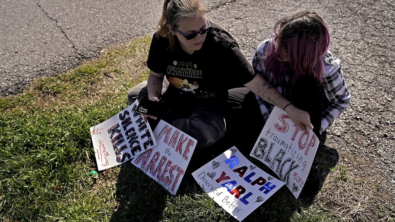 Trisha Loftis and her daughter Ashlyn, 13, sit outside the house where 16-year-old Ralph Yarl was shot several days earlier when he went to the wrong address to pick up his brothers, Monday, April 17, 2023, in Kansas City, Mo. (AP Photo/Charlie Riedel)