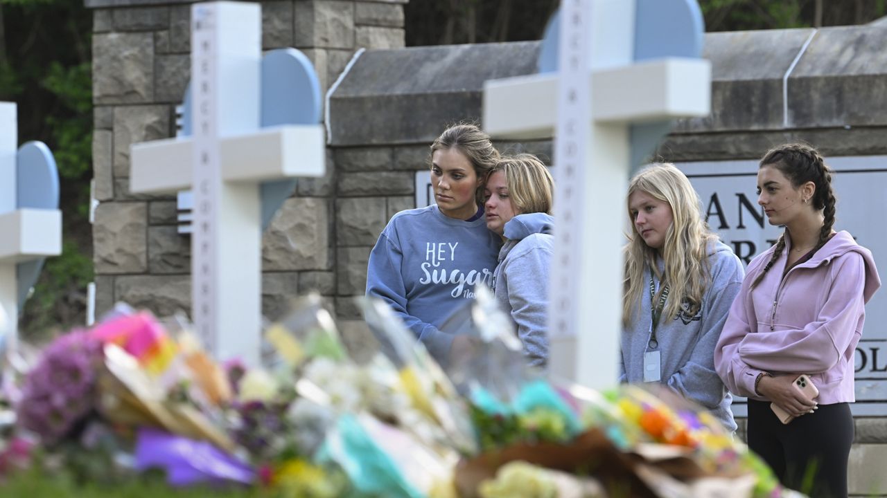 Students at a nearby school pay respects at a memorial for the people who were killed, at an entry to Covenant School, Tuesday, March 28, 2023, in Nashville, Tenn. (AP Photo/John Amis)