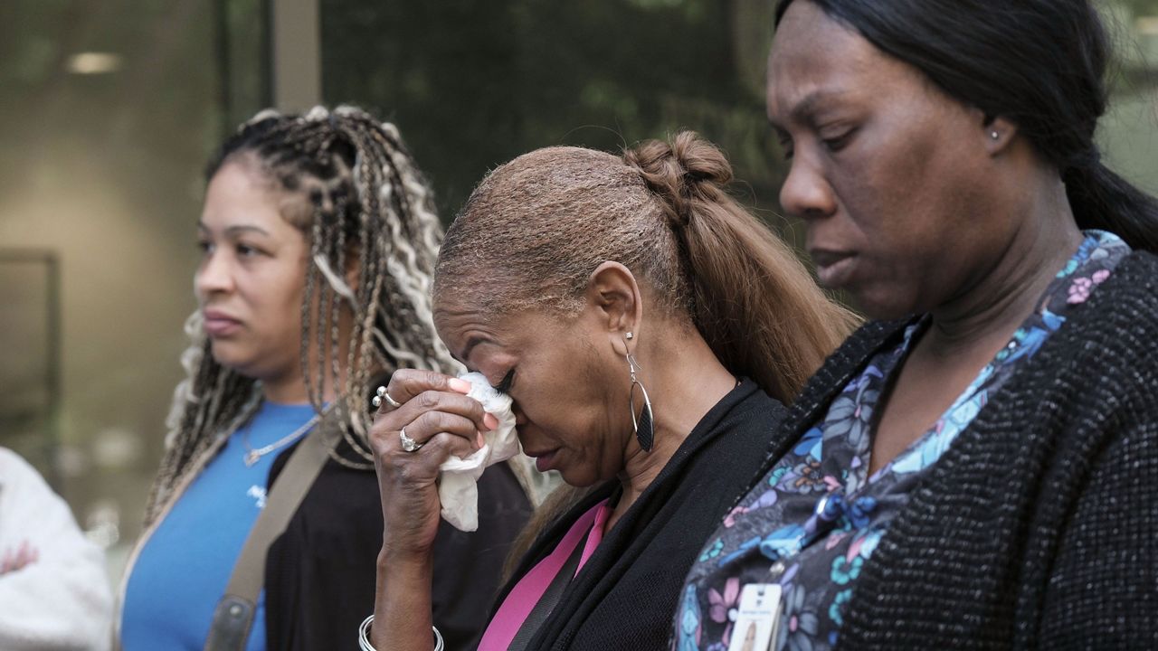 People stand outside a commercial building after a shooting, Wednesday, May 3, 2023, in Atlanta. (AP Photo/Ben Gray)