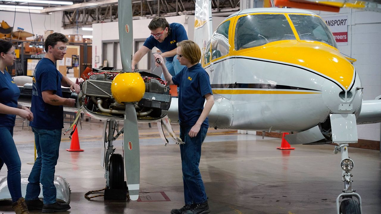 Students at the Pittsburgh Institute of Aeronautics from left: Nikki Reed, William Onderdonk, Jeffrey Natter and Joshua Lindberg study an engine on a Cessna 310 aircraft in West Mifflin, Pa., Tuesday, May 2, 2023. Students graduating from PIA have been awed by how much they're in demand. Recruiters are desperately seeking more aircraft mechanics for the airlines, airplane manufacturers, and repair shops that need them. (AP Photo/Gene J. Puskar)