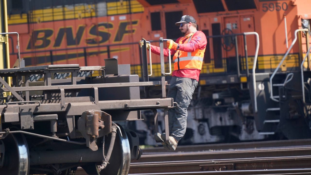 A worker rides a rail car at a BNSF rail crossing in Saginaw, Texas, Wednesday, Sept. 14, 2022. Tens of thousands of engineers remain frustrated with the lack of paid sick time and the demands railroads like BNSF are making in negotiations despite the progress that has been made in 2023 with sick time deals for most of the other rail unions. (AP Photo/LM Otero)