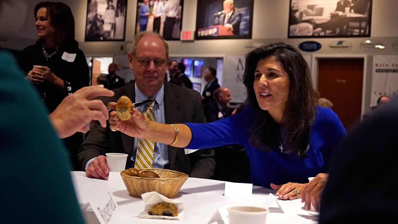 Republican presidential candidate Nikki Haley passes an autographed wooden egg to a guest during a breakfast gathering at Saint Anselm College, Wednesday, May 24, 2023, in Manchester, N.H. (AP Photo/Charles Krupa)