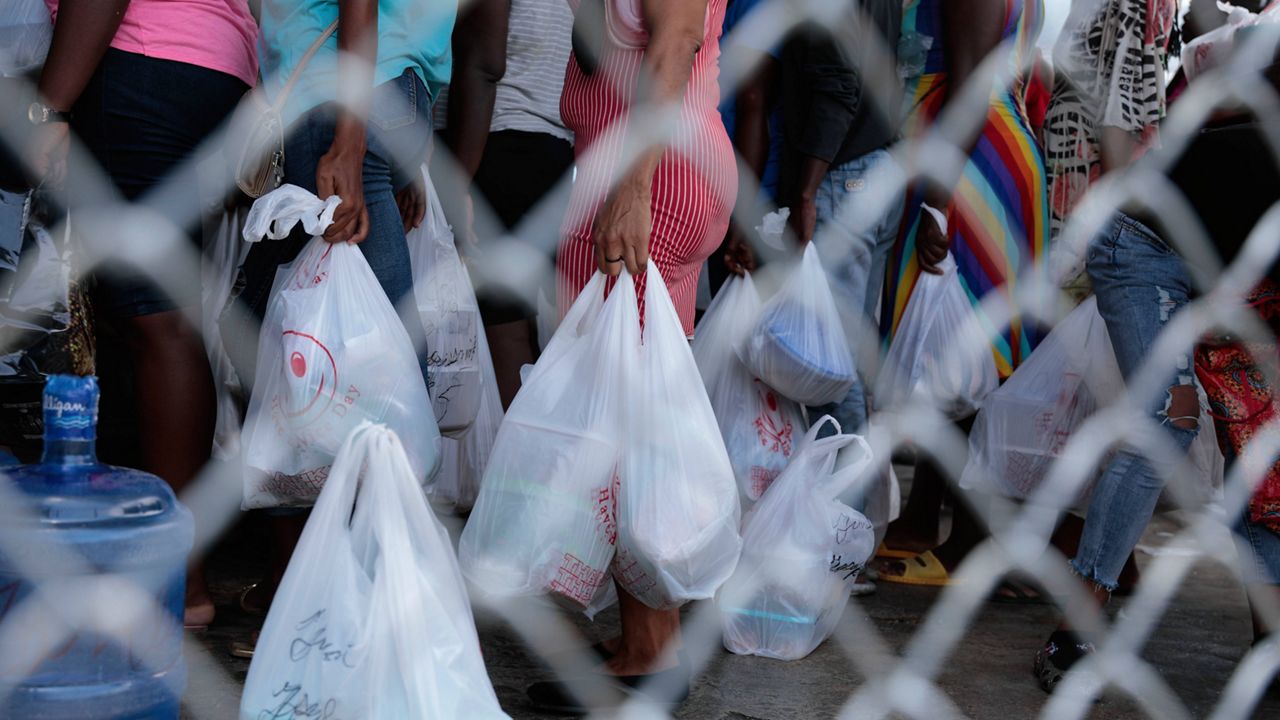 People gather outside the National Penitentiary for their turn to deliver food to their jailed relatives in downtown Port-au-Prince, Haiti, Thursday, June 1, 2023. In December 2022, the University of Florida published a study that found that men in Haiti’s prisons were on a starvation-level diet, consuming fewer than 500 calories a day. (AP Photo/Odelyn Joseph)