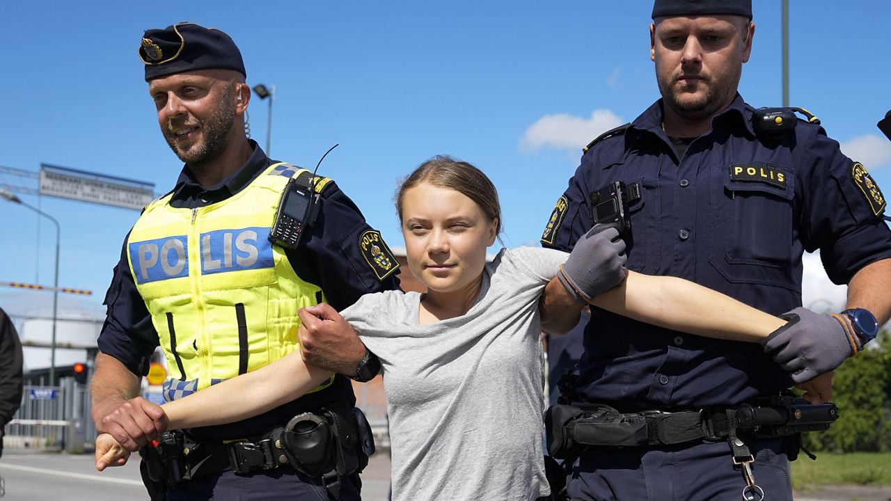 Climate activist Greta Thunberg is detained by police during an action for blocking the entrance to an oil facility in Malmo, Sweden, Monday, July 24, 2023. (AP Photo/Pavel Golovkin)