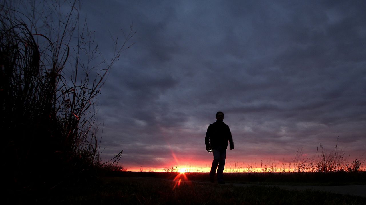A man walks along a trail during sunset near Manhattan, Kan. In 2022, about 49,500 people took their own lives in the U.S., the highest number ever, according to data from the Centers for Disease Control and Prevention released Thursdaty. (AP Photo/Charlie Riedel, File)