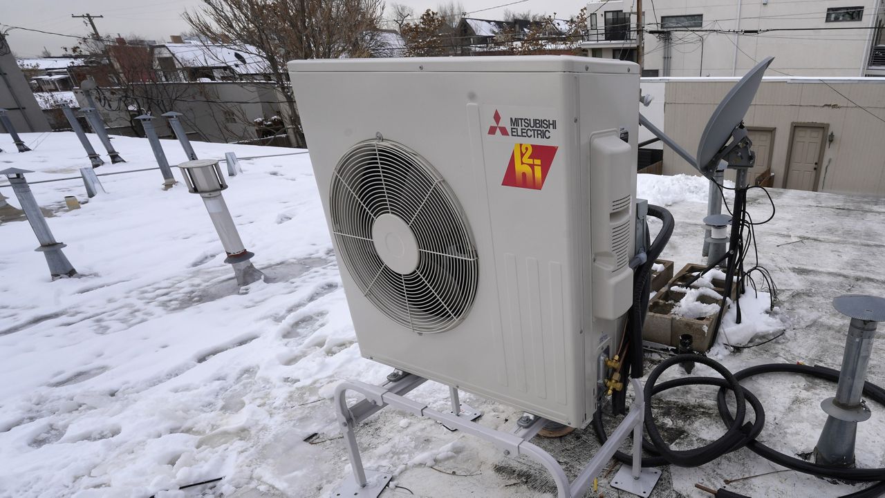 FILE - A condenser sits on the roof during the installation of a heat pump on Jan. 20, 2023 (AP Photo/David Zalubowski, File)