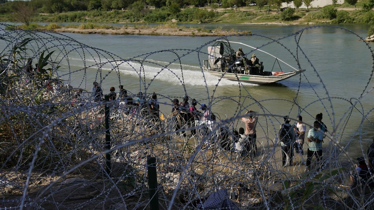 Migrants who crossed into the U.S. from Mexico are met with concertina wire along the Rio Grande, Thursday, Sept. 21, 2023, in Eagle Pass, Texas. U.S. authorities say illegal border crossings from Mexico fell 14% in October from a month earlier, following three months of big increases. The decline comes during the resumption of deportation flights to Venezuela, shortly after Venezuelans replaced Mexicans as the largest nationality appearing at the border. (AP Photo/Eric Gay, File)