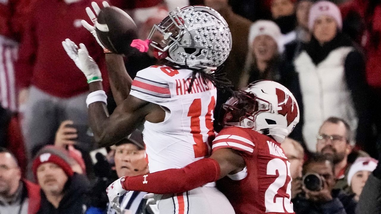 Ohio State's Marvin Harrison Jr. (18) cqatches a pass with Wisconsin's Jason Maitre (23) defending during the first half of an NCAA college football game Saturday, Oct. 28, 2023, in Madison, Wis. (AP Photo/Morry Gash)