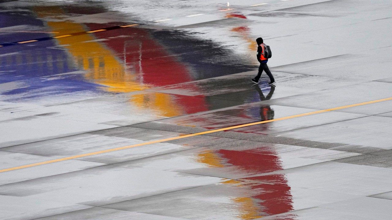 A ground operations crew member walks past a Southwest Airlines jet sitting at a gate, Dec. 28, 2022, at Sky Harbor International Airport in Phoenix. The federal government may be preparing to penalize Southwest Airlines for thousands of flight cancellations that affected more than 2 million travelers last December. Southwest disclosed the potential fine on Monday, Oct. 30, 2023 and said it couldn't estimate how large it might be. (AP Photo/Matt York, File)