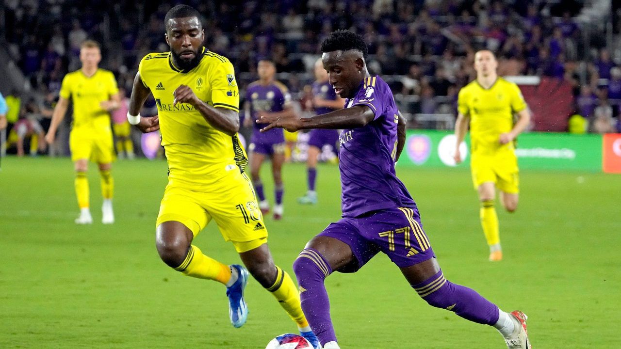 Orlando City forward Ivan Angulo (77) moves the ball to the goal against Nashville SC defender Shaq Moore (18) during the second half of an MLS playoff soccer match, Monday, Oct. 30, 2023, in Orlando, Fla. (AP Photo/John Raoux)