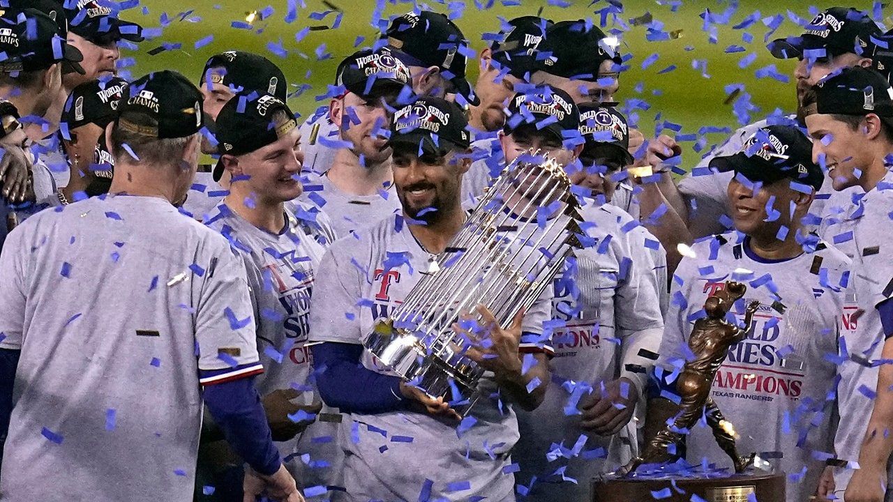 Texas Rangers' Marcus Semien holds the trophy as the Texas Rangers celebrate after winning Game 5 of the baseball World Series against the Arizona Diamondbacks Wednesday, Nov. 1, 2023, in Phoenix. The Rangers won 5-0 to win the series 4-1. (AP Photo/Gregory Bull)