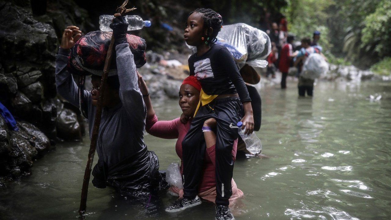 Haitian migrants wade through water as they cross the Darien Gap from Colombia to Panama in hopes of reaching the U.S., May 9, 2023. (AP Photo/Ivan Valencia, File)