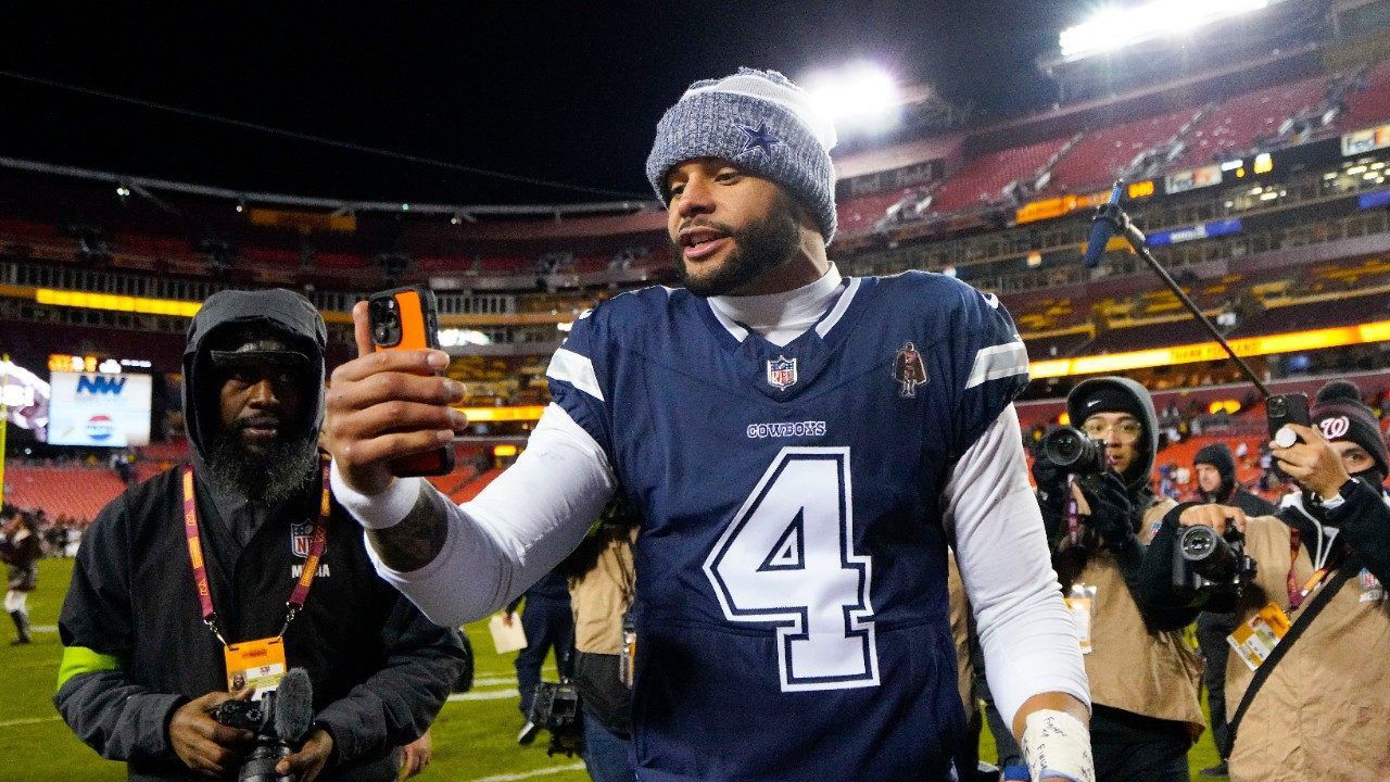 Dallas Cowboys quarterback Dak Prescott (4) using a phone as he heads off the field at the end of an NFL football game against the Washington Commanders, Sunday, Jan. 7, 2024, in Landover, Md. Dallas won 38-10. (AP Photo/Jessica Rapfogel)