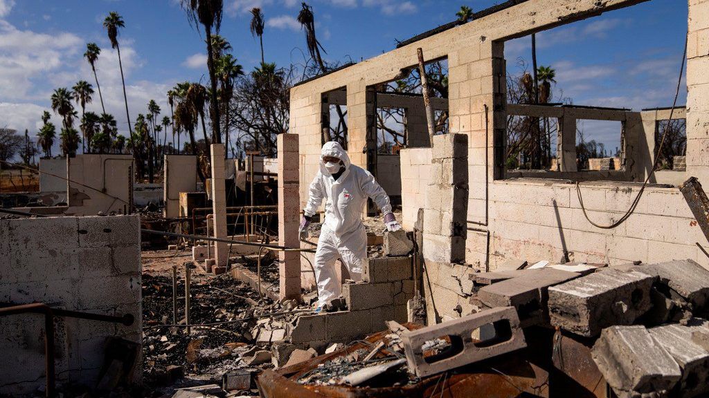 The Rev. Ai Hironaka, resident minister of the Lahaina Hongwanji Mission, walks through the grounds of his temple and residence destroyed by wildfire, Dec. 7, 2023, in Lahaina, Hawaii. Nearly six months after a wind-whipped wildfire destroyed the historic town of Lahaina, the Maui Police Department said Monday, Feb. 5, 2024, it is releasing a preliminary report about its response to the tragedy. (AP Photo/Lindsey Wasson, File)