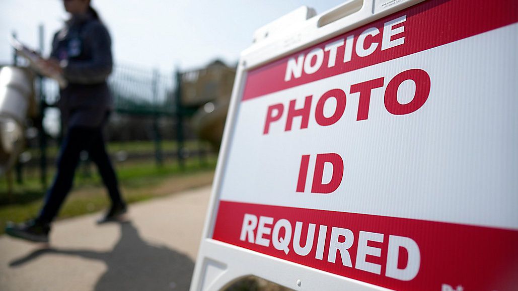 A Super Tuesday voter walks past a sign requiring a photo ID at a polling location Tuesday, March 5, 2024, in Mount Holly, N.C. (AP Photo/Chris Carlson)