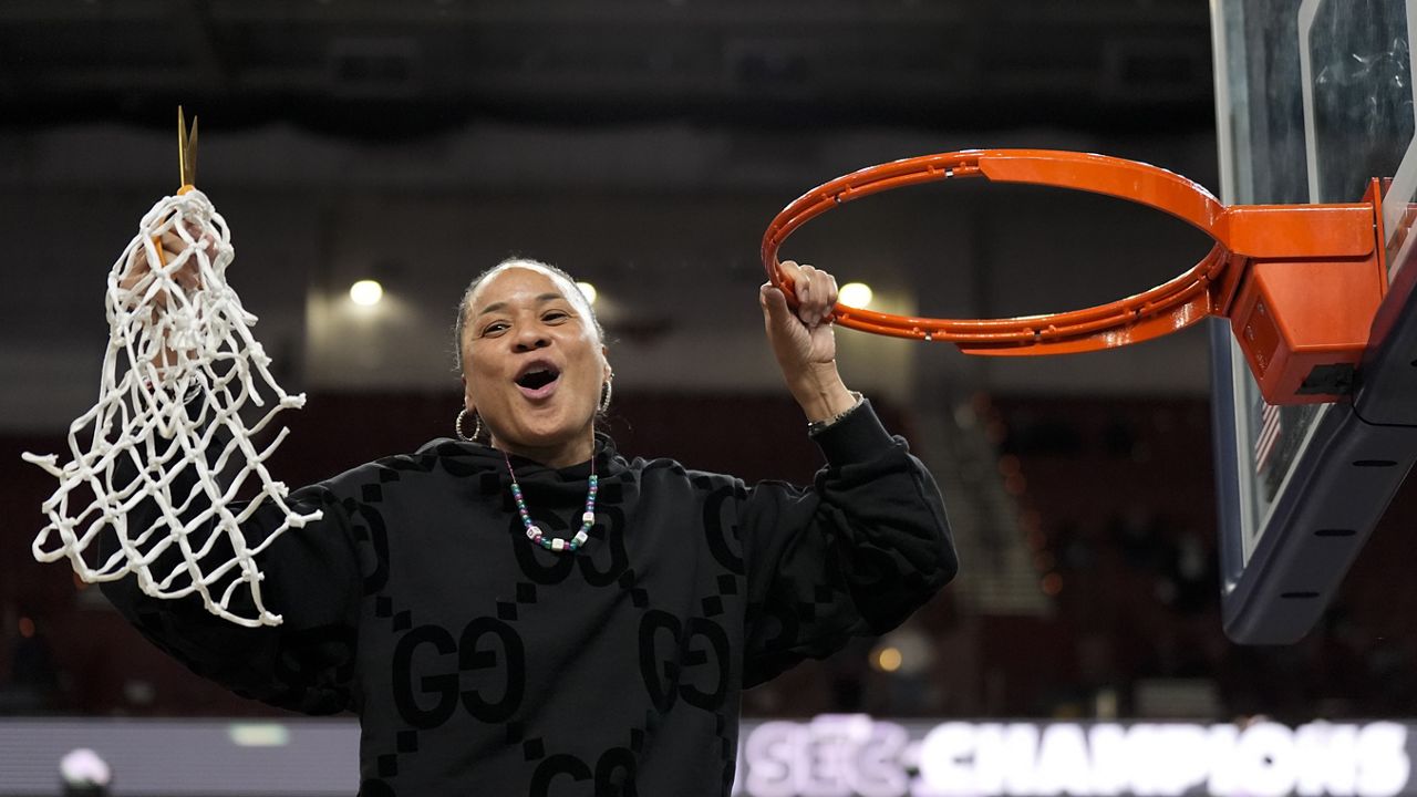 South Carolina head coach Dawn Staley celebrates cutting the net after their win against LSU in an NCAA college basketball game at the Southeastern Conference women's tournament final Sunday, March 10, 2024, in Greenville, S.C. (AP Photo/Chris Carlson)