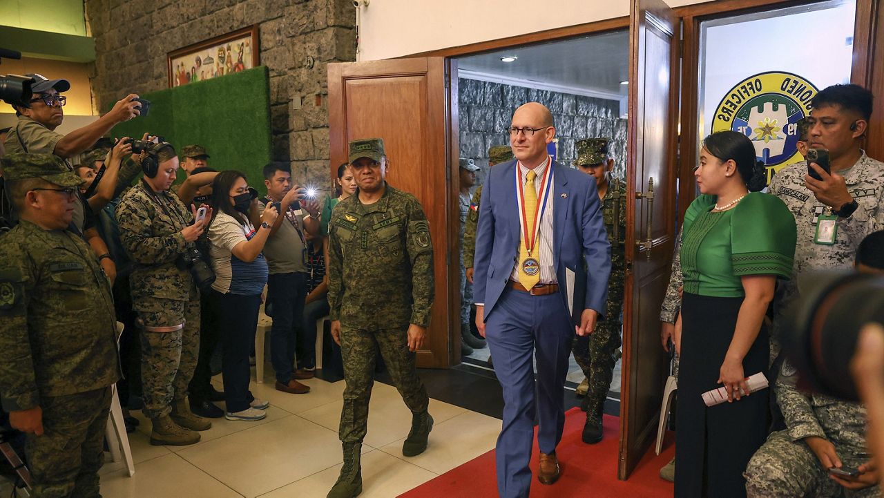 Philippines' military Chief Gen. Romeo Brawner Jr., center left, and U.S. Embassy Chargé d' Affaires Robert Ewing, center right, arrive during the opening ceremonies of the "Balikatan," or shoulder-to-shoulder, at Camp Aguinaldo military headquarters in Quezon City, Philippines on Monday April 22, 2024. (AP Photo/Basilio Sepe)