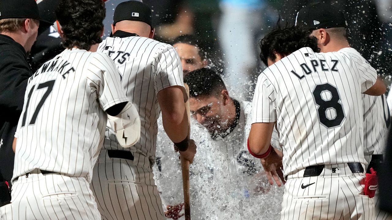 Chicago White Sox's Andrew Benintendi, center, celebrates with teammates after his winning two-run home run off Tampa Bay Rays relief pitcher Phil Maton to end a 10-inning baseball game Saturday, April 27, 2024, in Chicago. (AP Photo/Charles Rex Arbogast)