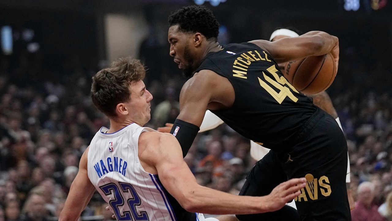 Orlando Magic forward Franz Wagner (22) fouls Cleveland Cavaliers guard Donovan Mitchell (45) and falls to the floor in the first half of Game 7 of an NBA basketball first-round playoff series Sunday, May 5, 2024, in Cleveland. (AP Photo/Sue Ogrocki)