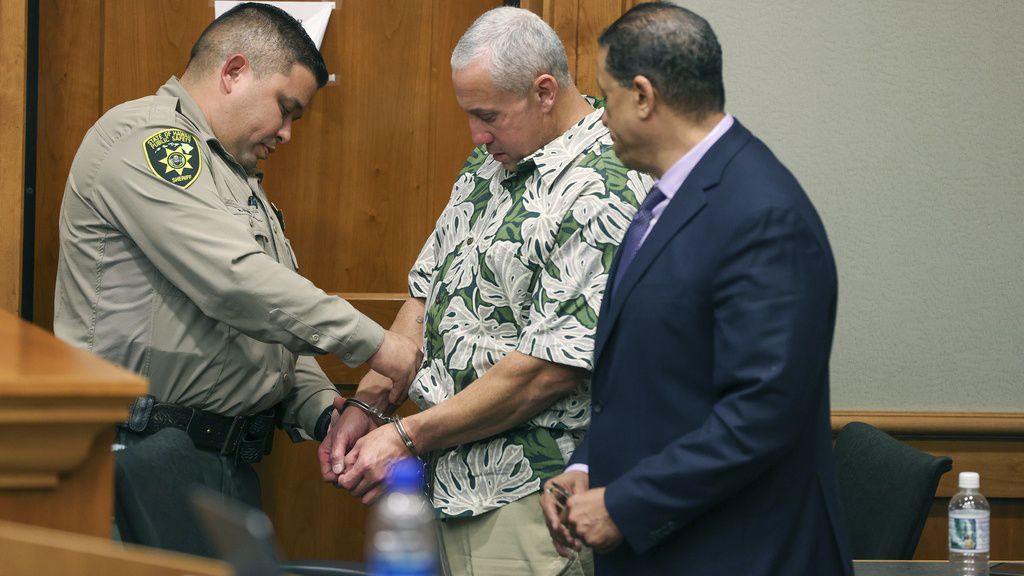 A court officer removes Albert "Ian" Schweitzer's handcuffs following the judge's decision to release him from prison immediately, after spending more than 20 years in prison, Jan. 24, 2023, in Hilo, Hawaii. A man who was identified as a new suspect in the murder and sexual assault of a woman visiting Hawaii more than three decades ago committed suicide after police took a DNA swab from him, but before he could be arrested, attorneys said in court filings late Sunday, July 28, 2024.The DNA work represented a major development in a case that was in the headlines last year when Schweitzer, ,a man who'd been incarcerated for more than 20 years for the murder, was released based on fresh evidence. (Marco Garcia/The Innocence Project via AP Images, File)