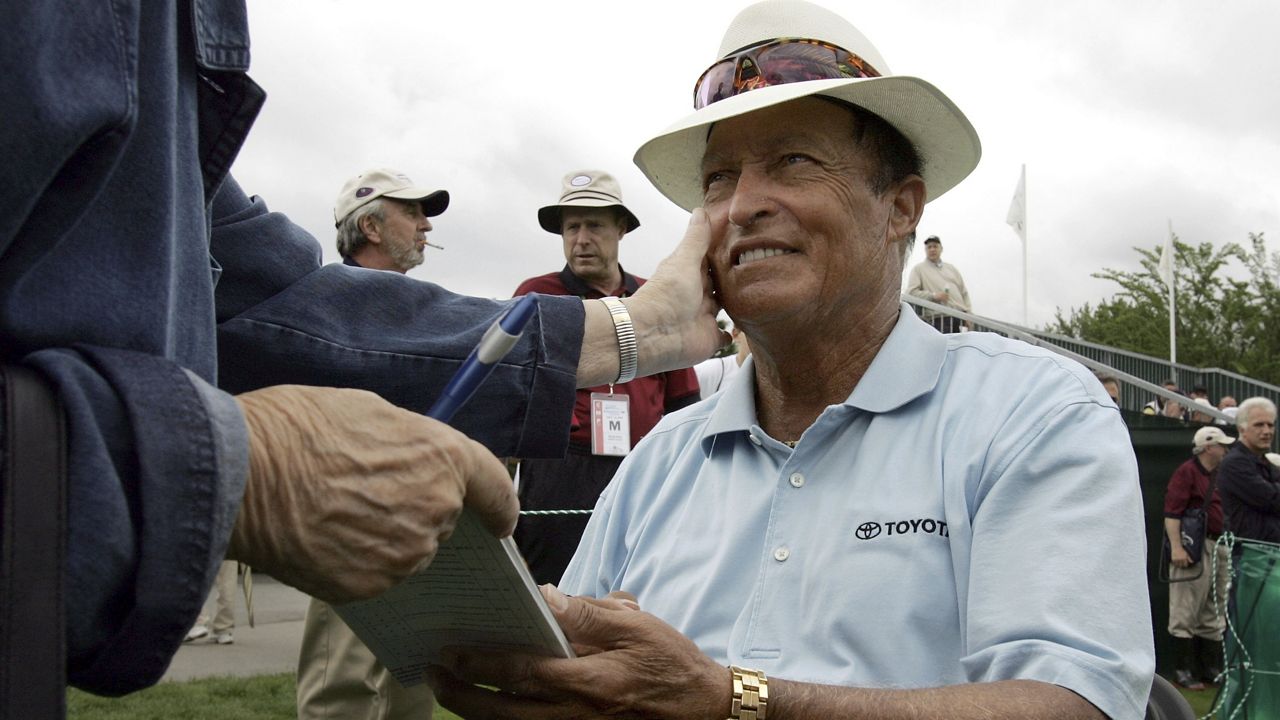 Chi Chi Rodriguez, of Puerto Rico, smiles while signing an autograph at the Nashawtuc Country Club in Concord, Mass., Friday, June 9, 2006. (AP Photo/Steven Senne, File)