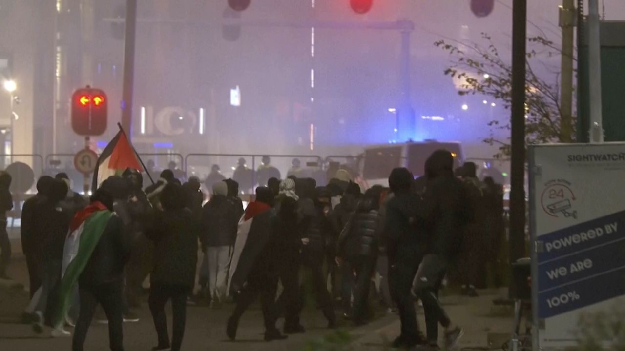 In this image taken from video, a group of pro-Palestinian protesters walk toward police line, with police vans driving in the background, near the soccer stadium in Amsterdam, Netherlands, Thursday, Nov. 7, 2024. (RTL Nieuws via AP)