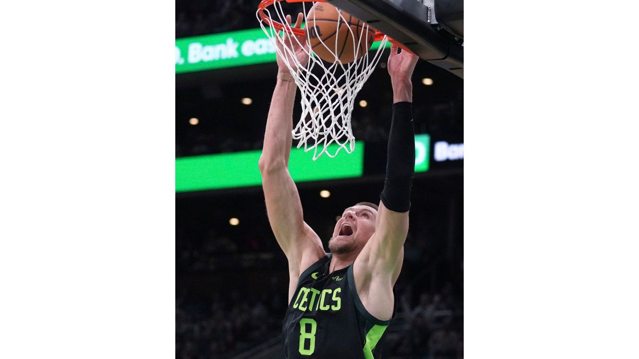 Boston Celtics center Kristaps Porzingis (8) dunks during the second half of an NBA basketball game against the Los Angeles Clippers, Monday, Nov. 25, 2024, in Boston. (AP Photo/Charles Krupa)