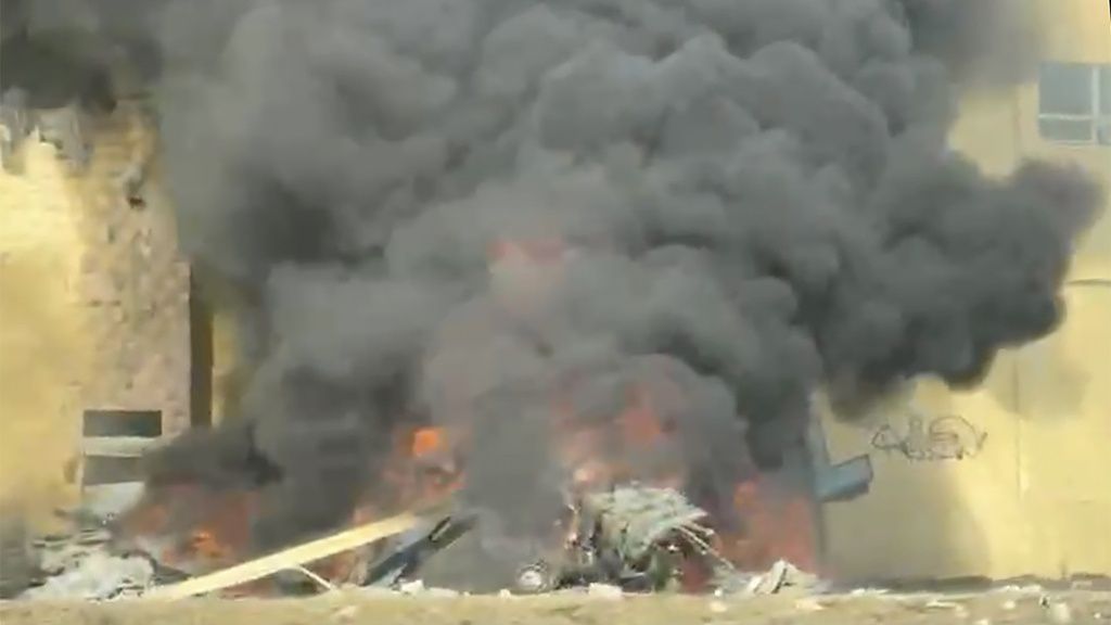 This image made from a video shows the wreckage of a small cargo plane on a training flight after it crashed into a vacant building and burst into flames shortly after taking off from the Daniel K. Inouye International Airport in Honolulu, Hawaii, Tuesday, Dec. 17, 2024. (Lama Tonga via AP)