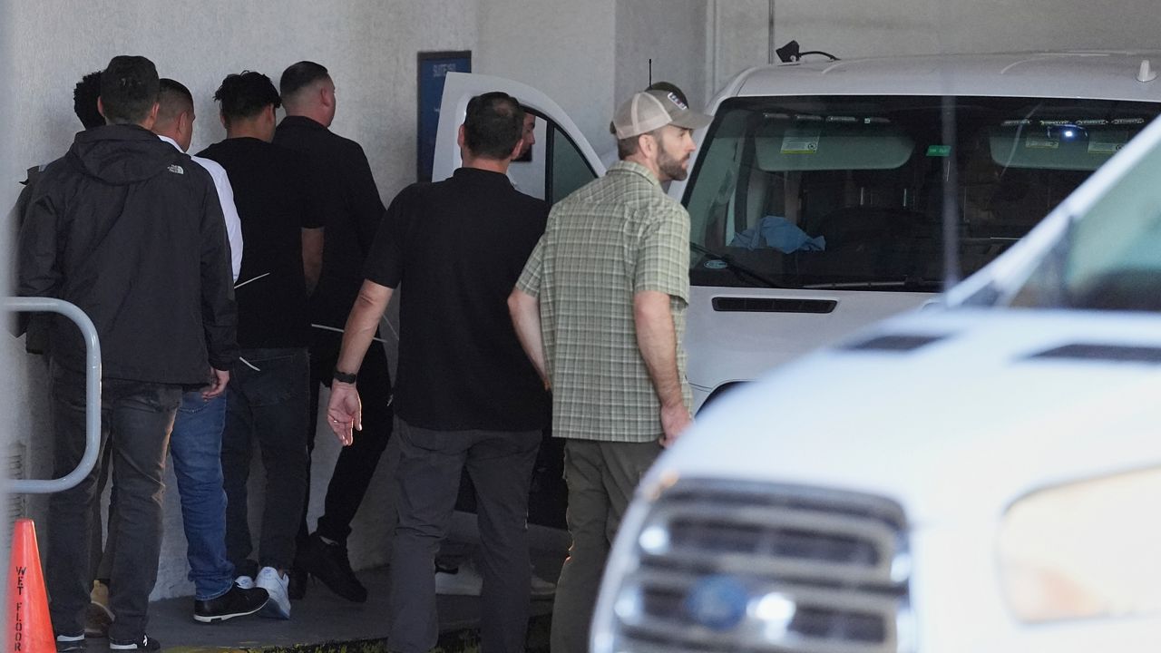 Plainclothes agents from U.S. Immigration and Customs Enforcement load people detained at the Miami Immigration Court, their wrists bound with zip ties, into a Department of Homeland Security van, Wednesday, May 21, 2025, in Miami. (AP Photo/Rebecca Blackwell)