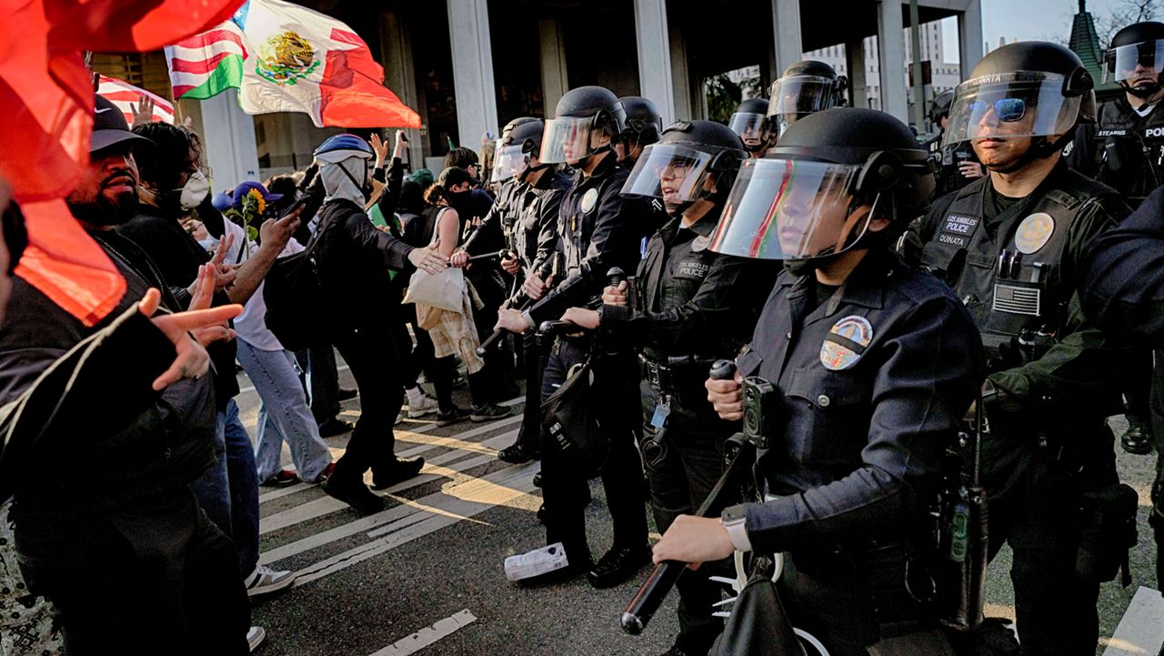 Los Angeles police in riot gear form a skirmish line and push back protesters down a street away from a federal building in downtown Los Angeles on Monday, June 9, 2025. (AP Photo Jae Hong)