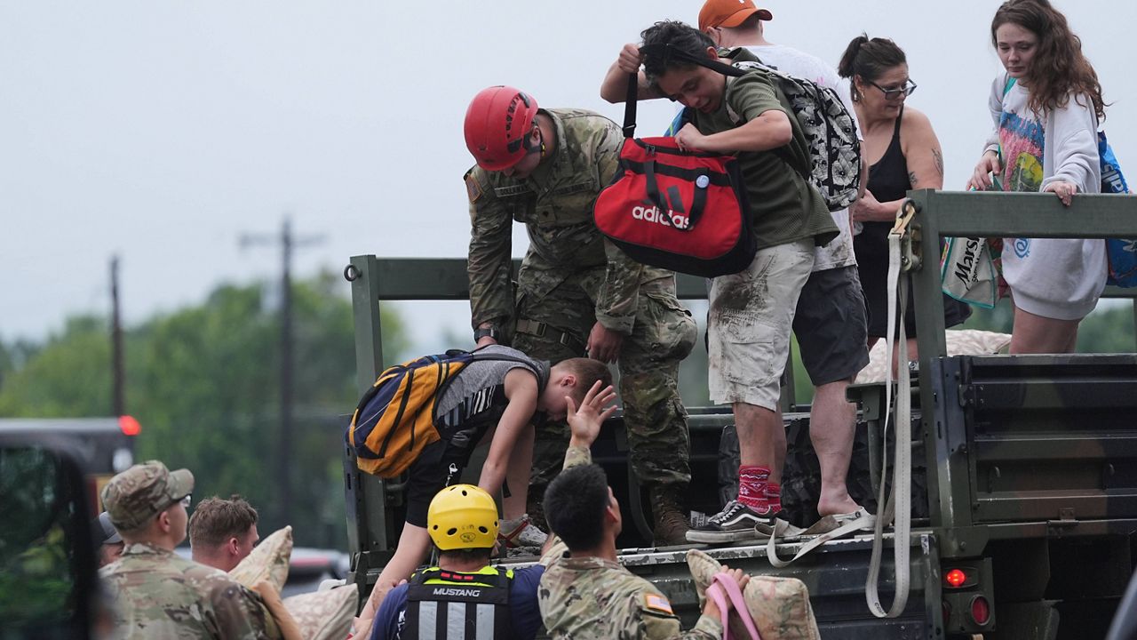 First responders deliver people to a reunification center after flash flooding in the area, Friday, July 4, 2025, in Ingram, Texas. (AP Photo/Eric Gay)