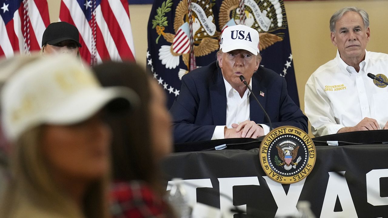 President Donald Trump speaks as Texas Gov. Greg Abbott, right, listens during a roundtable discussion with first responders and local officials at Hill Country Youth Event Center in Kerrville, Texas, during a tour to observe flood damage, Friday, July 11, 2025. (AP Photo/Jacquelyn Martin)