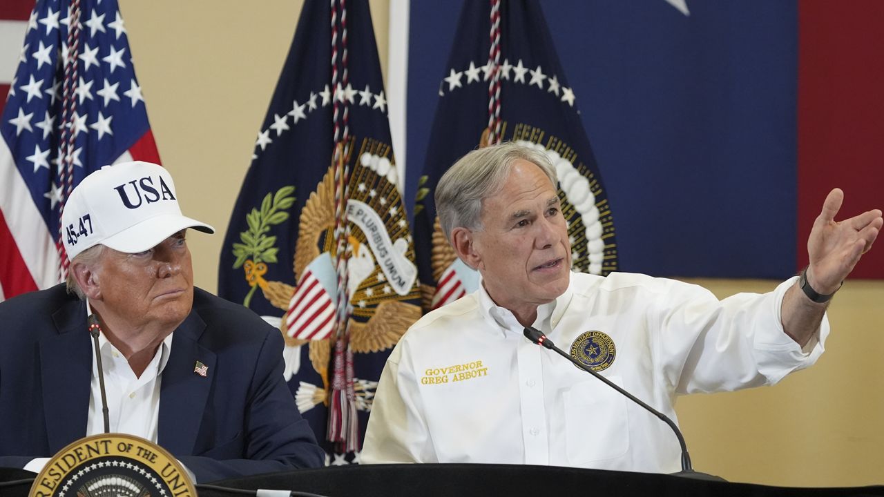 Texas Gov. Greg Abbott speaks as President Donald Trump listens during a roundtable discussion with first responders and local officials at Hill Country Youth Event Center in Kerrville, Texas, during a tour to observe flood damage, Friday, July 11, 2025. (AP Photo/Jacquelyn Martin)