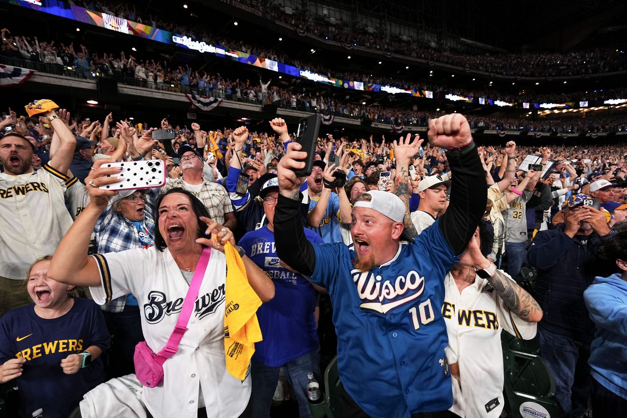 Fans roar and raise their arms at the American Family Field watch party