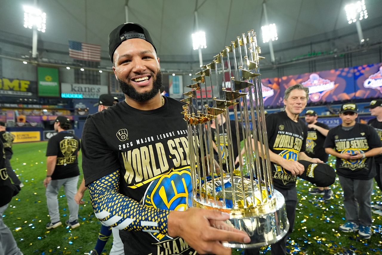 Jackson Chourio smiling while holding the Commissioner's Trophy after the Milwaukee Brewers won the 2026 World Series