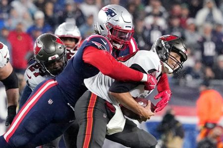 Tampa Bay Buccaneers quarterback Tom Brady (12) meets with New England  Patriots long snapper Jo …