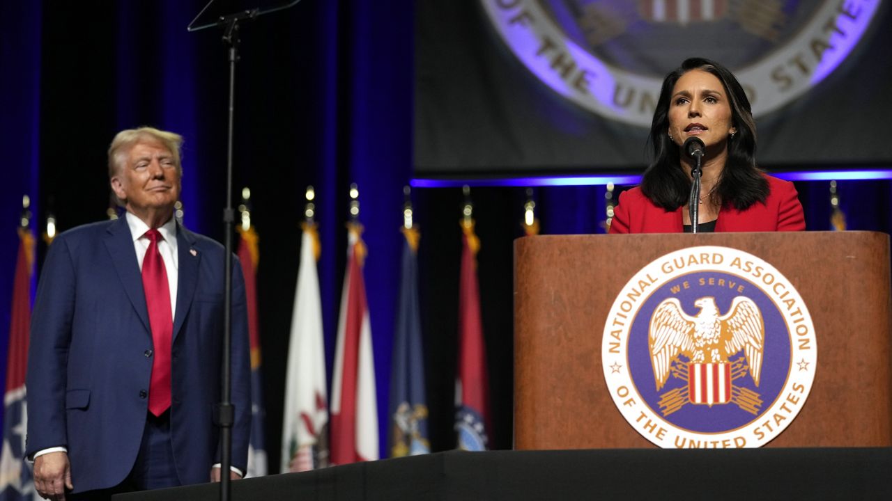 Republican presidential nominee former President Donald Trump, left, looks on as former Rep. Tulsi Gabbard of Hawaii, speaks at the National Guard Association of the United States' 146th General Conference, Monday, Aug. 26, 2024, in Detroit. (AP Photo/Carolyn Kaster)