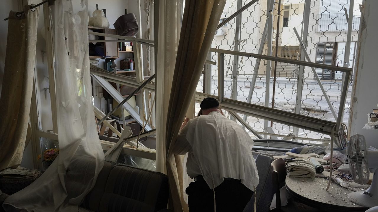 A man examine his damaged apartment that was hit by a rocket fired from Lebanon, in Kiryat Yam, northern Israel, on Tuesday, Oct. 8, 2024. (AP Photo/Ariel Schalit)