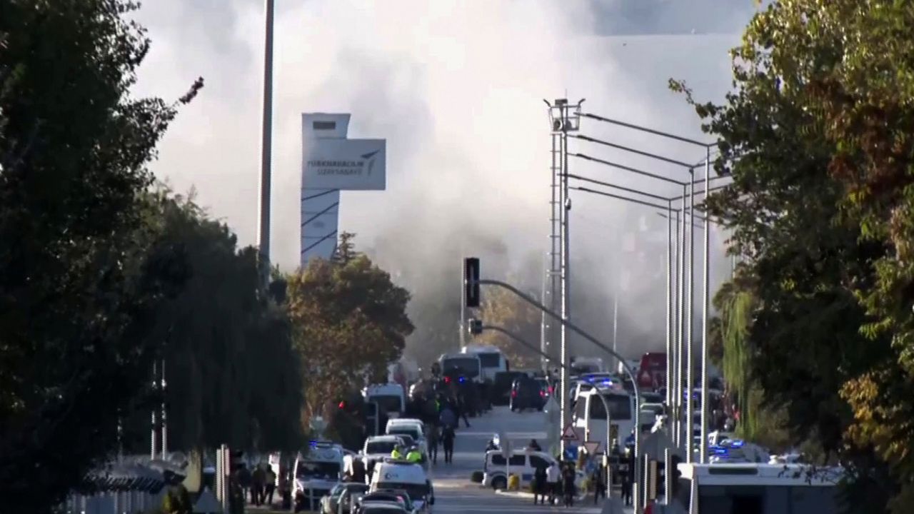 Smoke raises as emergency rescue teams and police officers attend outside Turkish Aerospace Industries Inc. on the outskirts of Ankara, Turkey, Wednesday, Oct. 23, 2024. (IHA via AP)