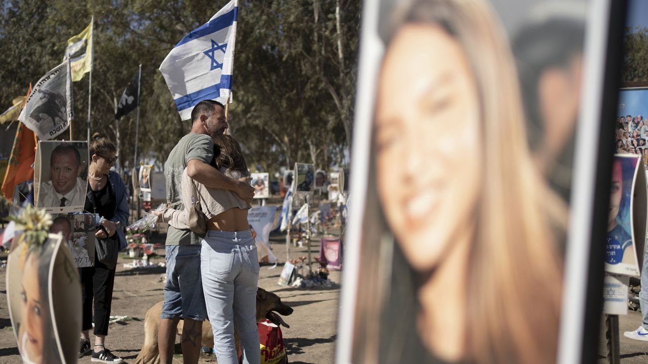 A family visits the the memorial marker of their loved one, Bar Lior Nakmuli, at the site of the Nova music festival, where hundreds of revelers were killed or kidnapped by Hamas, on the Jewish holiday of Simchat Torah, marking one year in the Hebrew calendar since the attack, near Kibbutz Re'im, southern Israel near the Gaza Strip, Thursday, Oct. 24, 2024. (AP Photo/Maya Alleruzzo)